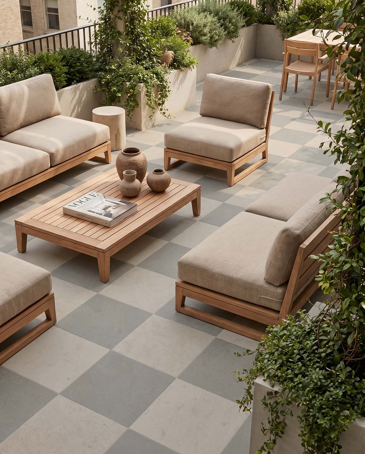 Outdoor patio area with seats around and coffee table, beige and light grey tiles on floor in checkerboard pattern.