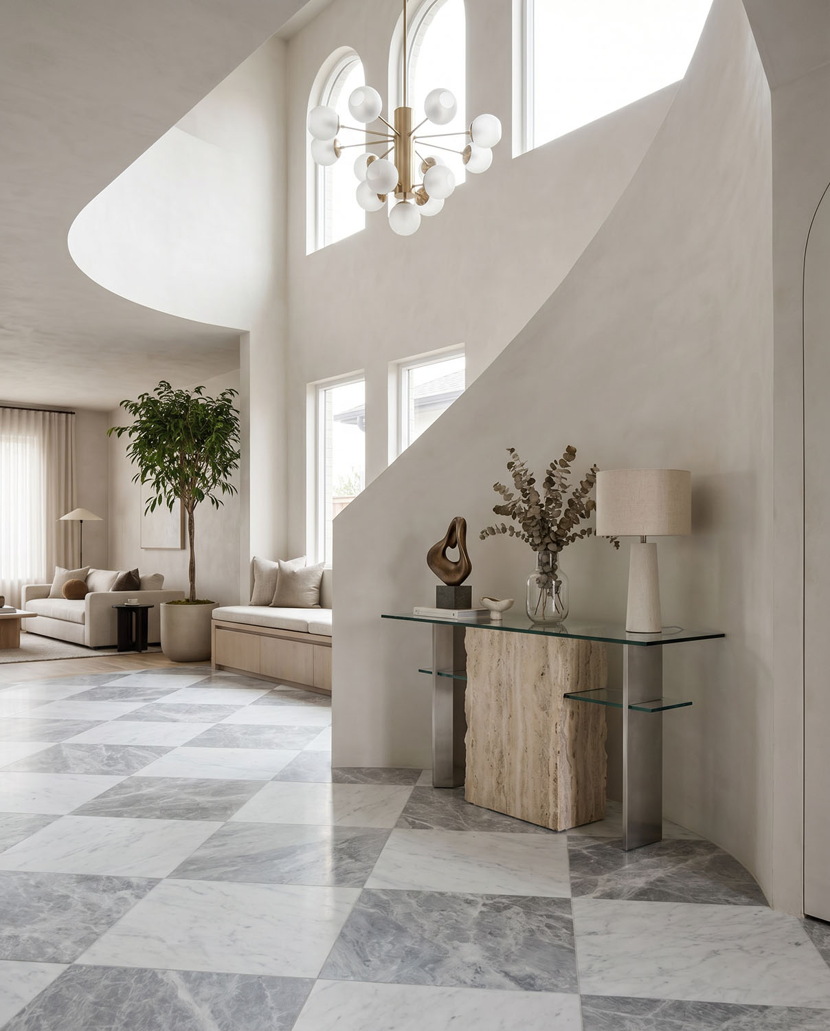 Entry home area with high ceilings and abstract decor, light grey and white natural stone tiles in checkerboard pattern on floor.
