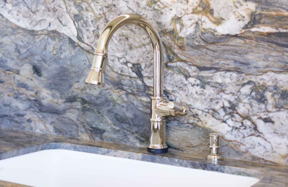 Periwinkle Fusion Blue Quartzite vanity and full-height backsplash in a coastal South Florida bathroom with brushed gold fixtures.