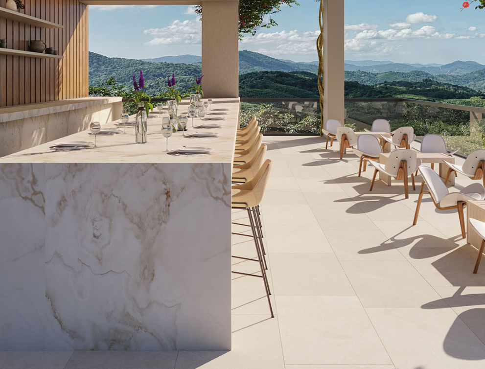 Continuum porcelain surfaces on a covered outdoor terrace bar with a mountain view and light large-format flooring.